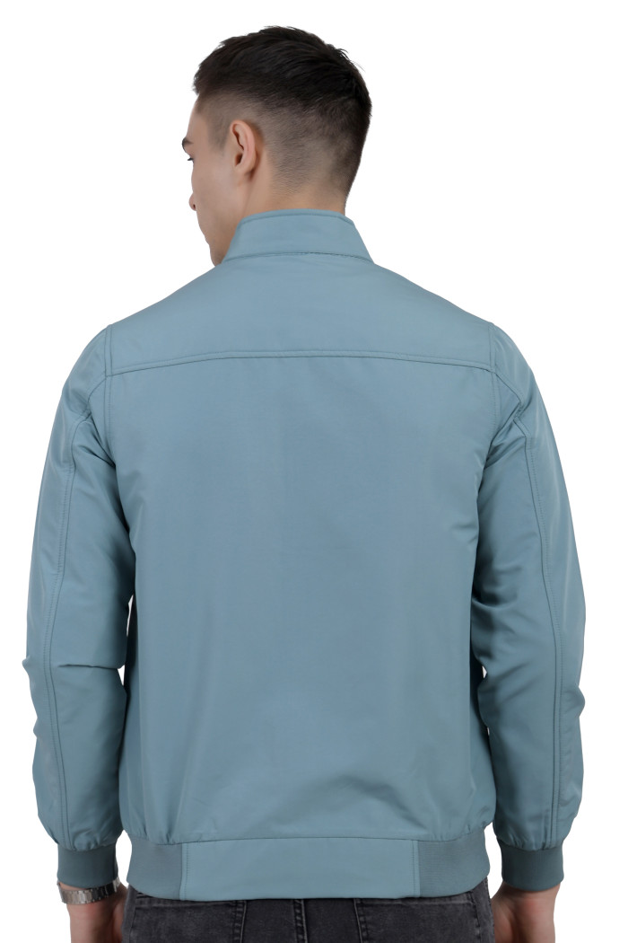 A back pose of a man wearing an Aqua Blue matt Finish Lightweight Jacket with high neck collar, zipper closure and pocket in hand designed for casual winter layering and comfort.